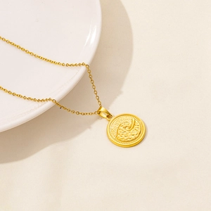 Macro shot of gold coin pendant featuring embossed spiral wave texture and fine bead edging