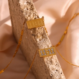 Detailed close-up of gold stainless steel 11:11 rectangle pendant with rhinestone accents