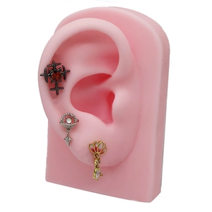 Close-up of heart zircon and celestial ear studs on a silicone ear model