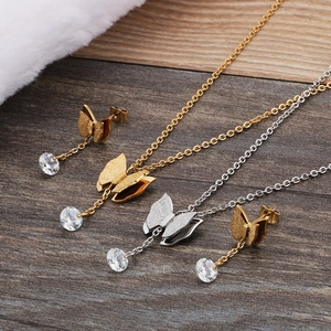 Elegantes Schmuckset mit Schmetterlingen und Zirkonia in Gold und Silber auf Holz