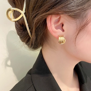 Close-up of a model wearing gold geometric interlocking hoop earrings for women