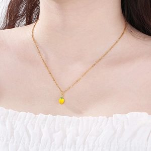 Dettaglio di una collana creativa placcata in oro con ciondolo a forma di peperone giallo