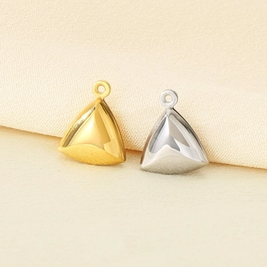 Macro shot of 18K gold and silver hollow triangle pendants with polished metal finish