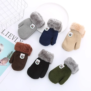 Flat lay of colorful thick fleece-lined winter knit gloves with shield badges and fur cuffs