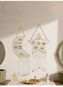 Detail of Nordic gold star and moon wall-mounted metal mesh jewelry organizer with hooks