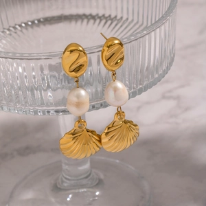 Gold-plated stainless steel shell pendant earrings with freshwater pearls on a display