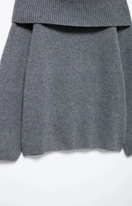 Detailed close-up of dark grey off-shoulder knit sweater with ribbed texture and folded collar