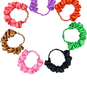 Close-up of pleated satin headbands in seven vibrant colors on a white background