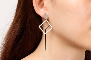 Close-up of geometric hollow rhombus earrings in rose gold finish on model