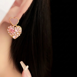 Pink heart earrings with gold plating and rhinestones on model with black hair