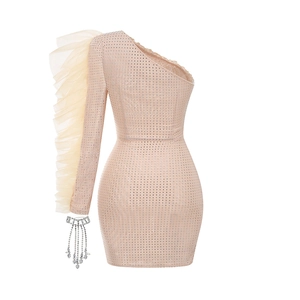 Detail of nude beige one-shoulder dress with sparkling rhinestones and mesh ruffle