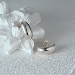 Close-up of S925 sterling silver stamp on polished star-shaped hoop earrings