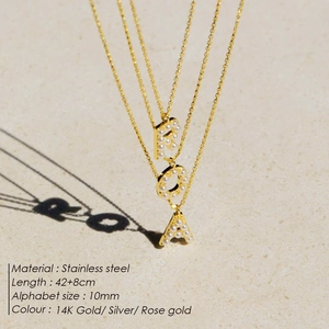 Detailed macro shot of stainless steel letter necklace with delicate pearl inlays