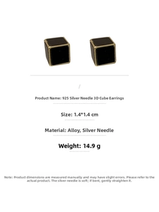 Vue détaillée de boucles d'oreilles cubes noirs avec bords dorés et tiges en argent 925