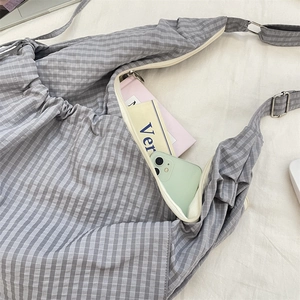 Detailed top view of large grey gingham nylon shoulder bag with adjustable silver buckle