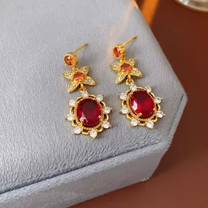 Vintage court style gold dangle earrings with oval red gems and star design accents