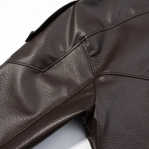 Détail macro de la texture du cuir marron foncé sur l'épaule d'une veste de moto