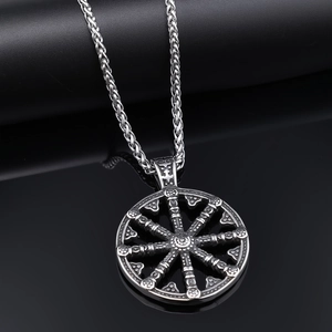 Detailed view of silver Viking compass pendant with gear design on dark reflective surface