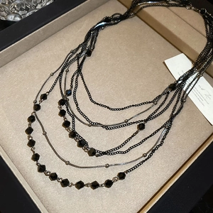 Detailed macro shot of layered crystal beaded necklace with sleek metallic dark finish