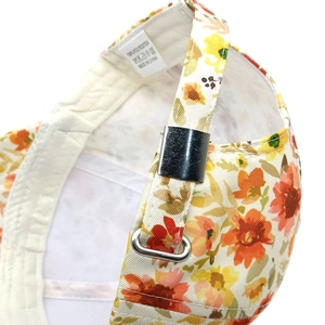 Detail of floral baseball cap with adjustable metal buckle and 100% polyester fabric texture