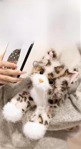 Close-up of cute realistic plush tabby cat with bright glass eyes and soft leopard pattern