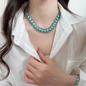 Détail d'un ensemble collier et bracelet bohème en argent avec résine verte et strass