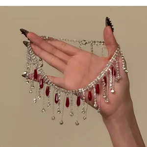 Macro shot of silver rhinestone fringe choker with red teardrop crystal pendants