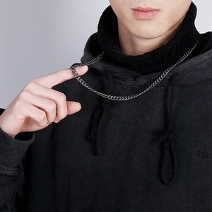 Detailed close-up of a vintage dark stainless steel keel chain worn by a male model