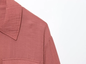 Detailed macro view of retro dusty rose cotton jacket collar with fine stitching texture