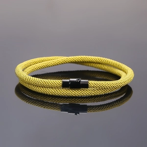 Close-up of yellow double-wrap braided bracelet with a black magnetic buckle clasp
