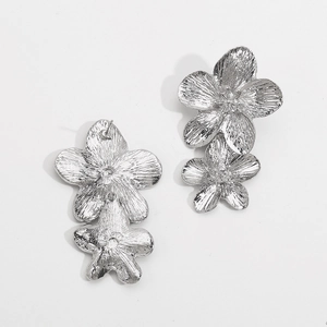 Detailed view of silver floral earrings with elegant brushed metal texture petals