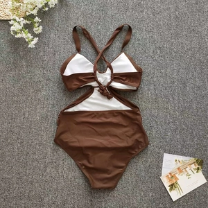 Detailed flat lay of brown and white cutout swimsuit with criss-cross back straps