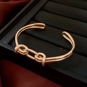 Dettaglio del bracciale ovale placcato oro 18K con nodo nautico su vassoio nero lussuoso