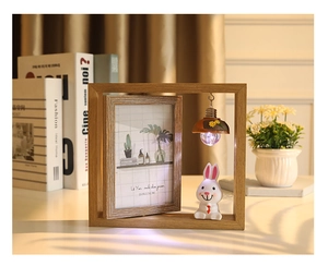 Détail d'un cadre photo rotatif de 6 pouces en bois avec mini ampoule et lapin blanc