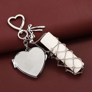 Detail of silver heart locket and white mesh lipstick holder on red leather