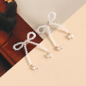 Detailed view of handmade crystal bow tassel earrings with sparkling glass beads