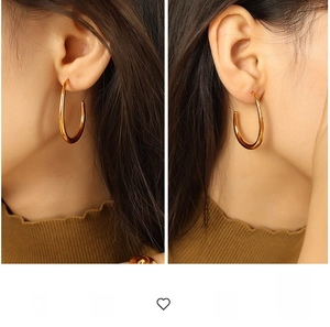 Detailed view of large gold-plated geometric hoop earrings with polished mirror finish