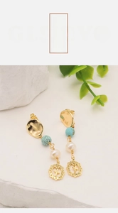 Détail de boucles d'oreilles plaquées or 18k avec perles d'eau douce et croix vintage