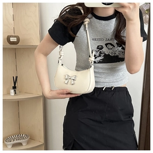 Cream white faux leather underarm bag featuring a silver bow and knotted shoulder strap