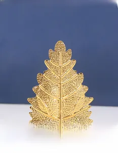 Detailed close-up of golden metal leaf ornament with realistic embossed veins and texture
