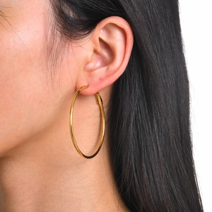 Close-up of 18k gold plated stainless steel hoop earring worn by a female model