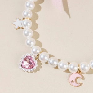 Detail of pet necklace with white pearls, pink heart crystal and enamel moon charms
