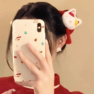 Detail of a red plush hair tie featuring a cute white lucky cat doll and soft embroidery