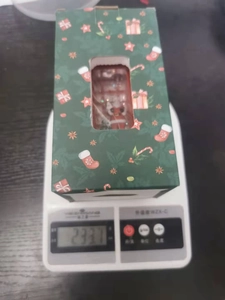 Macro shot of green Christmas phone booth lamp on scale weighing 233.7 grams