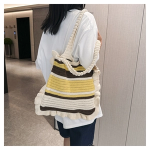 Shoulder shot of a striped handmade knit tote with ruffle trim and colorful pattern