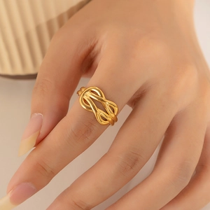 Close-up of a twisted irregular 18k gold plated stainless steel ring on a finger