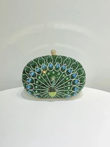 Macro view of green peacock clutch with blue rhinestones and elegant gold clasp