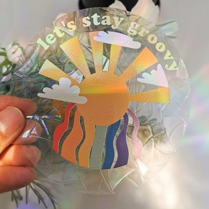 Holographic sun and rainbow prism window sticker with Let's Stay Groovy typography