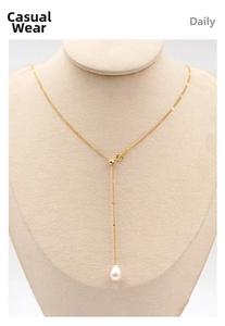Détail d'un collier en Y doré ajustable avec un pendentif perle en forme de goutte d'eau
