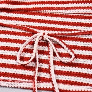 Vue macro d'un tissu en maille rayé rouge et blanc avec détail de cordon